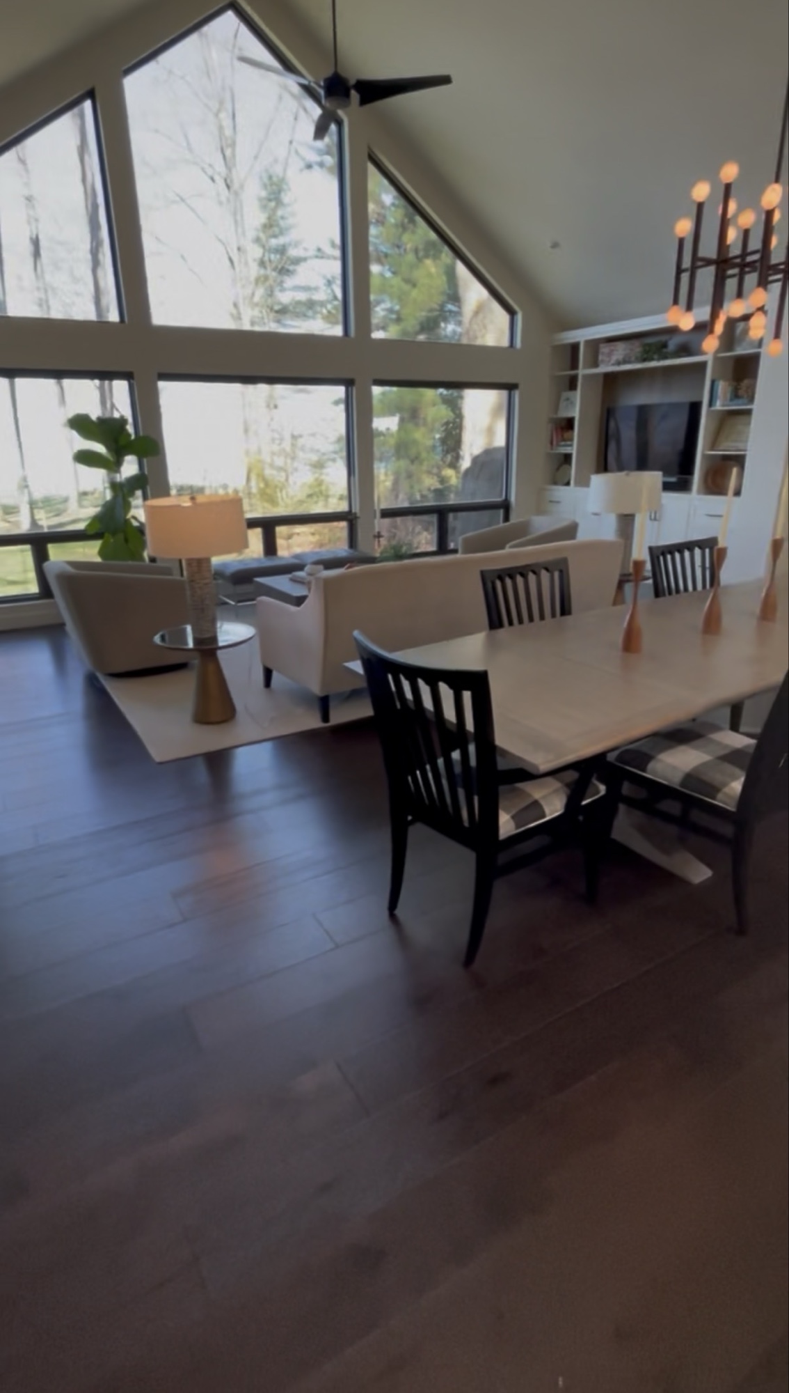 Open-plan living and dining area with cathedral windows and hardwood floors